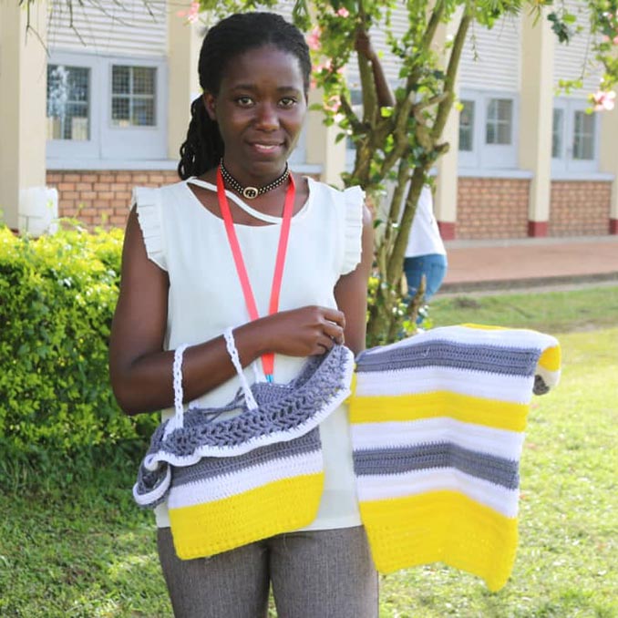 woman holding crocheted clothes